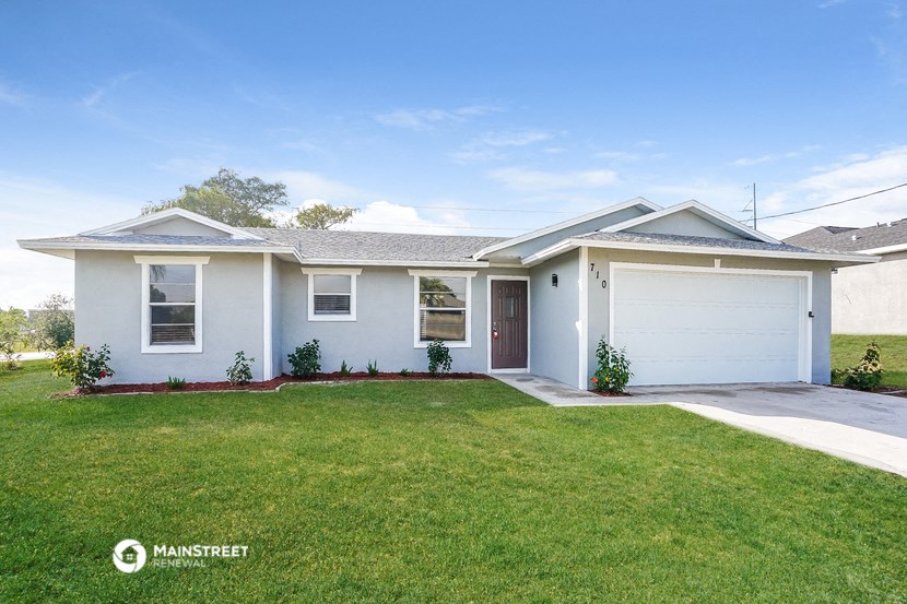 a white house with a lawn and a white garage door
