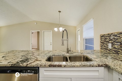 the kitchen has granite counter tops and stainless steel appliances