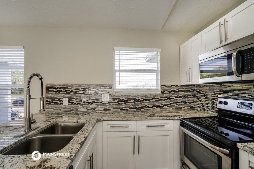 a kitchen with granite counter tops and black appliances