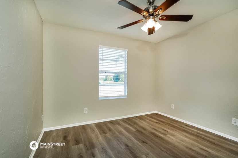 the bedroom has a ceiling fan and a window