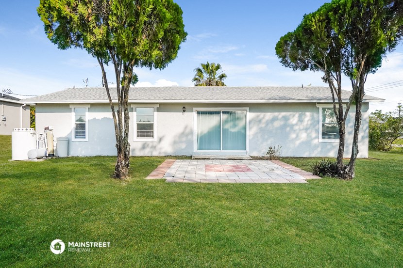 a white house with a lawn and trees