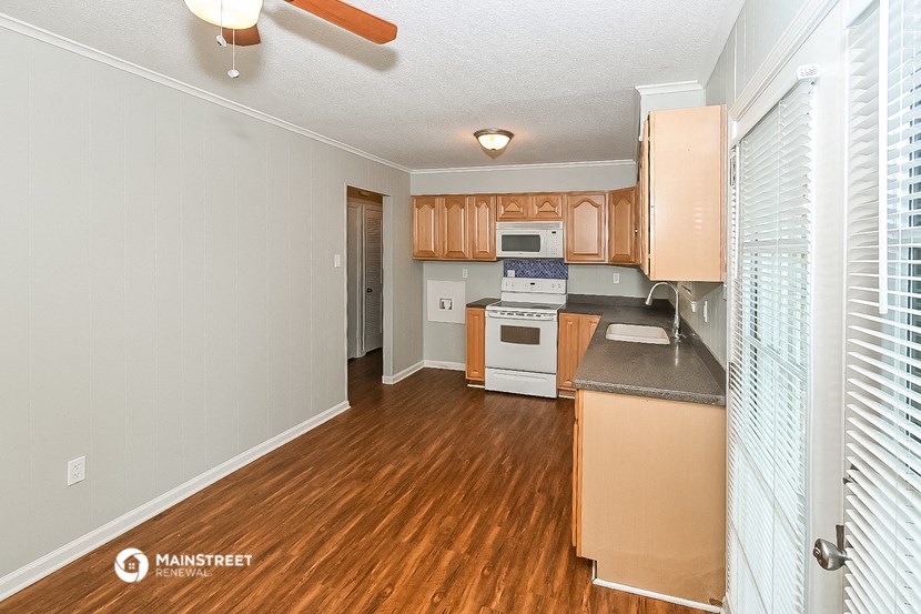 a kitchen with wood flooring and wooden cabinets