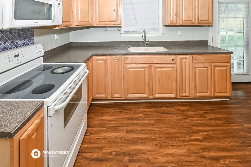 a kitchen with wooden cabinets and a stove and a sink