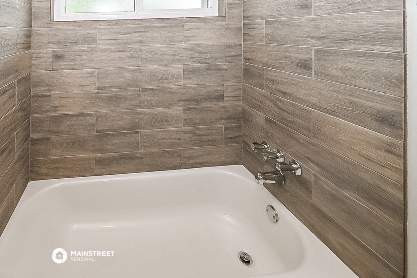 a white bath tub in a bathroom with wood tile