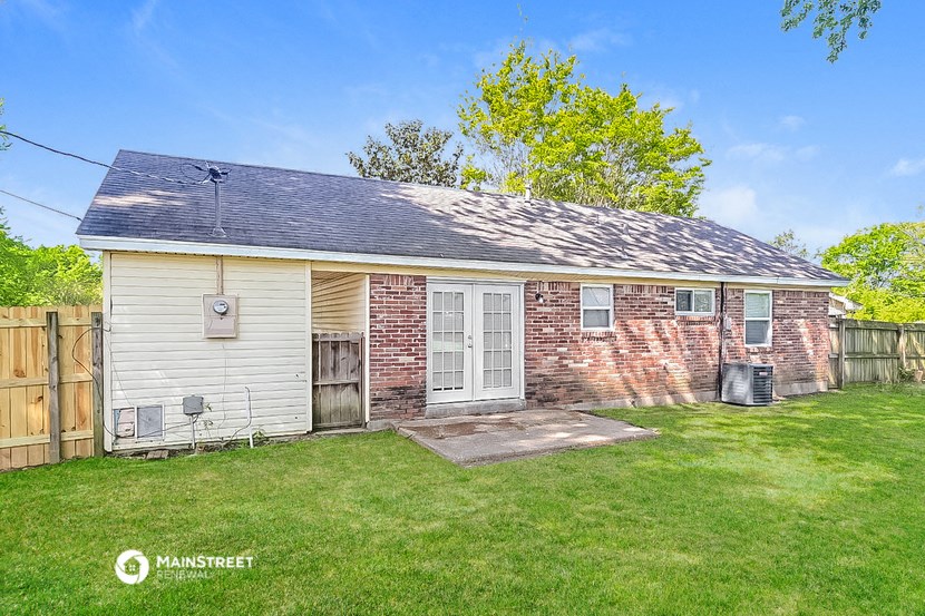 a small brick house with two doors and a grassy yard