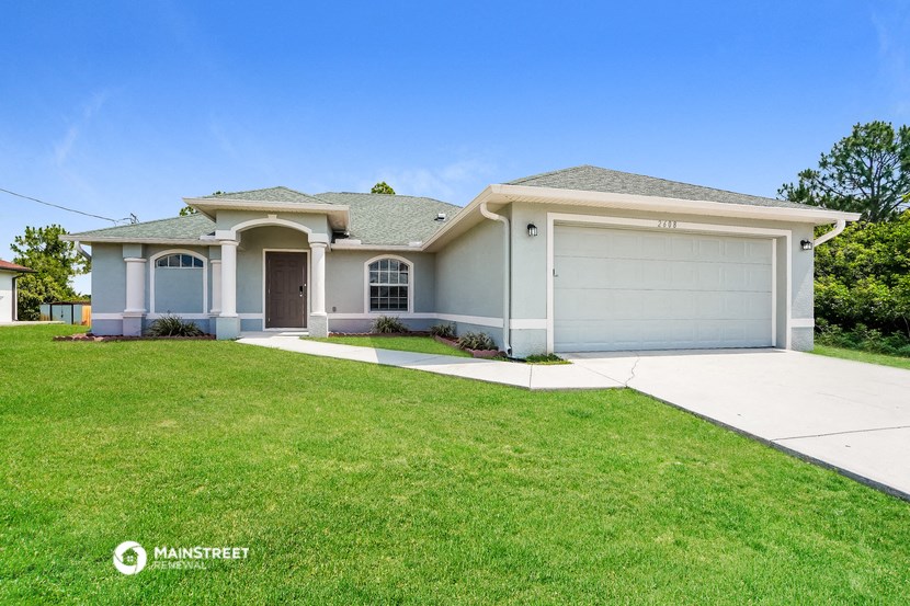 a white house with a lawn and a driveway