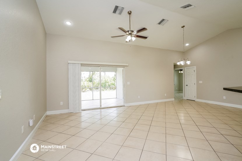 the spacious living room with tile flooring and a ceiling fan