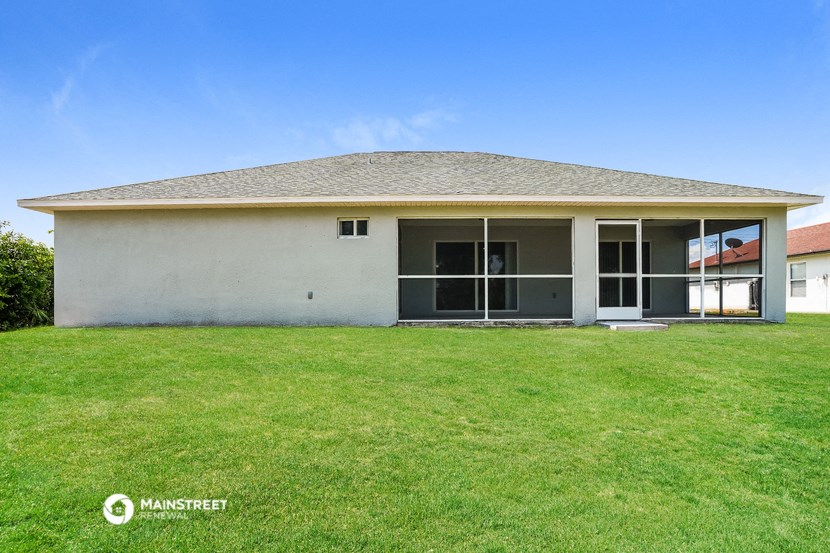 a small white house with a lawn in front of it