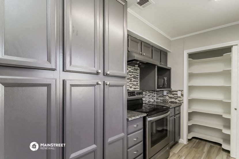 a kitchen with gray cabinets and a stove and a refrigerator