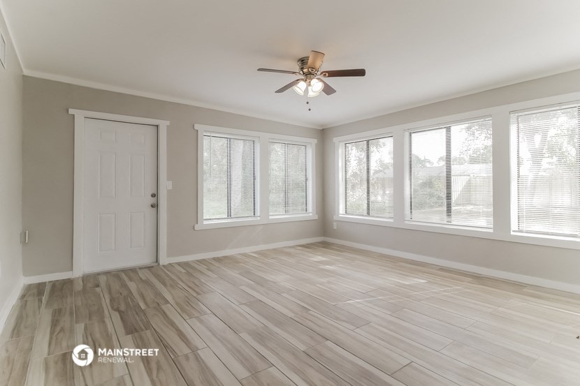 the living room of an empty house with a ceiling fan