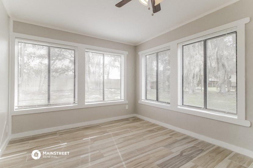 the living room of a new home with windows and wood flooring