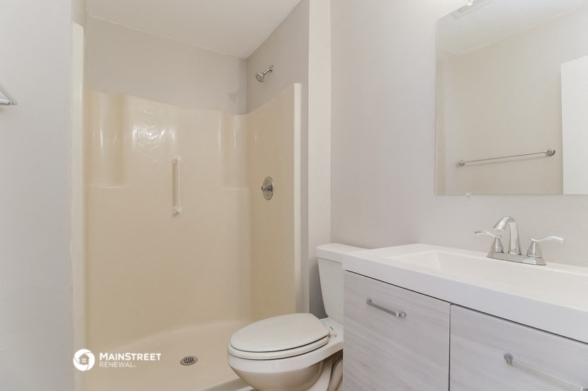 a bathroom with a toilet and a sink and a shower