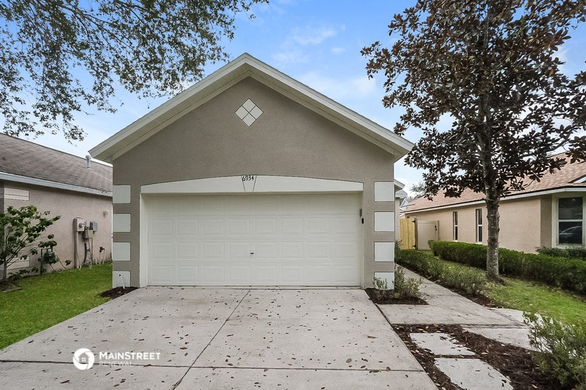 a white garage door in front of a white driveway