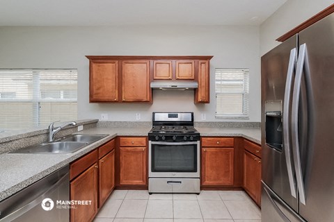 a kitchen with wooden cabinets and stainless steel appliances