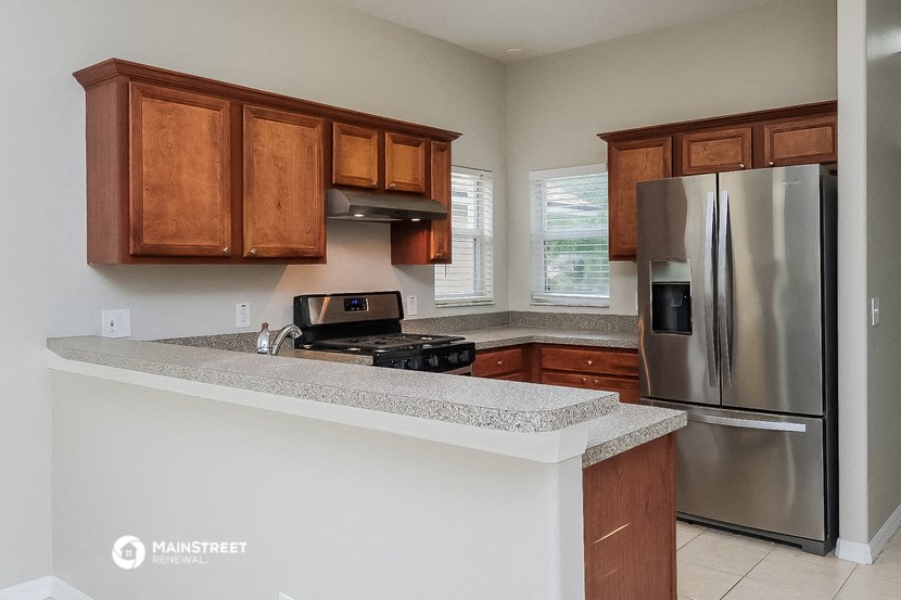 a kitchen with a counter top and a stainless steel refrigerator