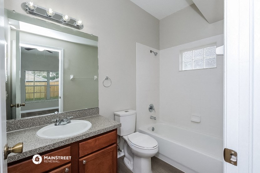 a bathroom with a toilet sink and tub and a mirror