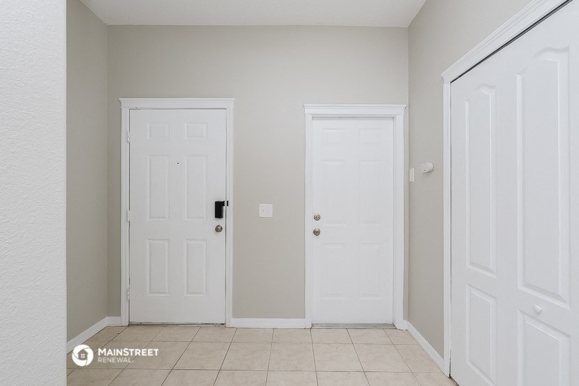 a room with two white doors and a tiled floor