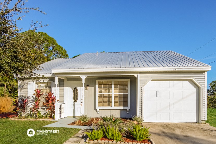 a small white house with a white garage door