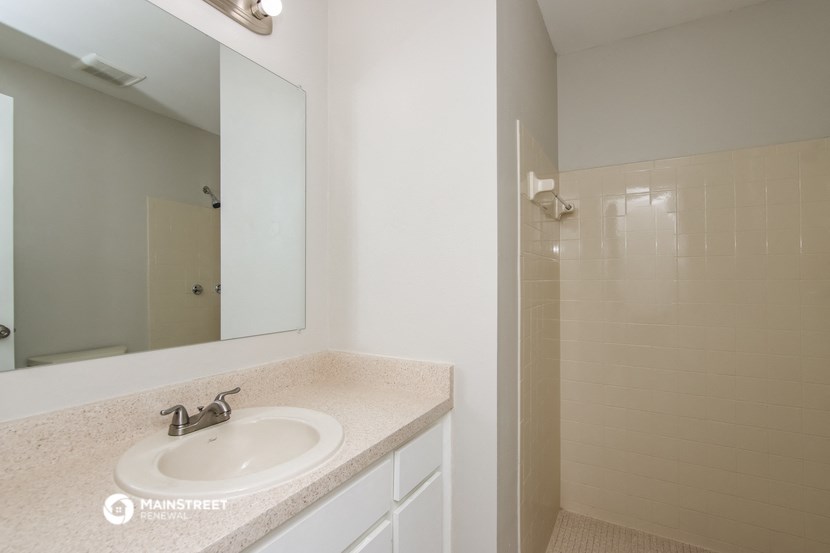 a bathroom with a sink and a mirror and a shower