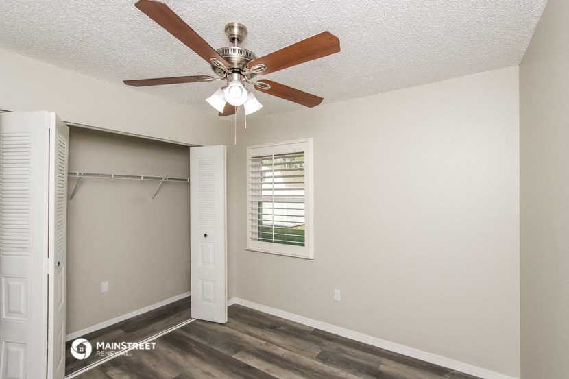 a bedroom with a ceiling fan and a closet