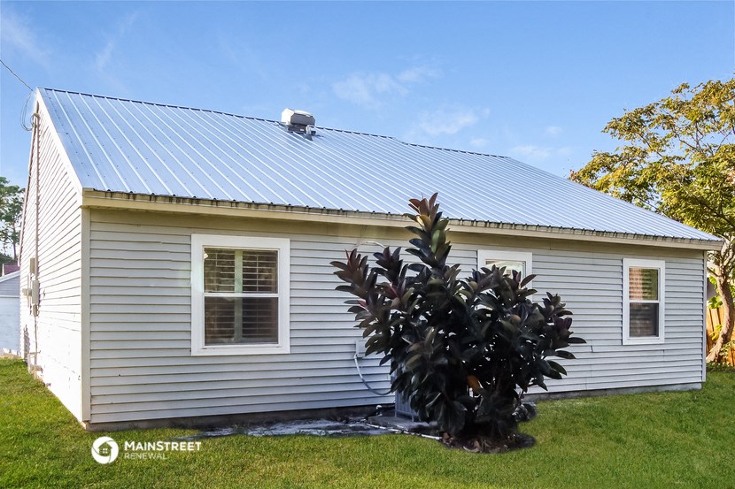 a white house with a plant in front of it