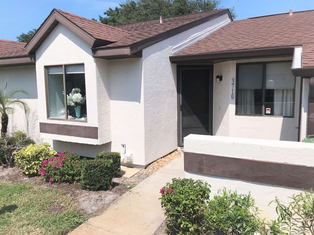 A house with a brown roof and white walls with a brown trim.