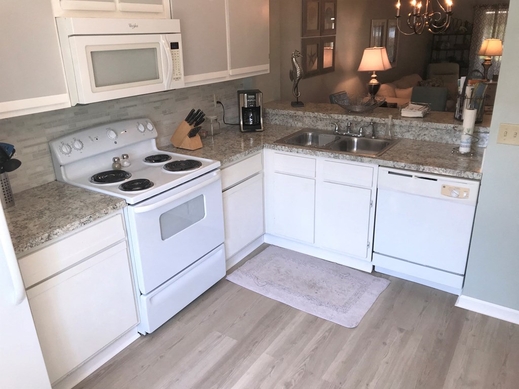 A kitchen with white appliances and cabinets.