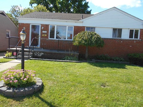 A house with a white front and a small garden.