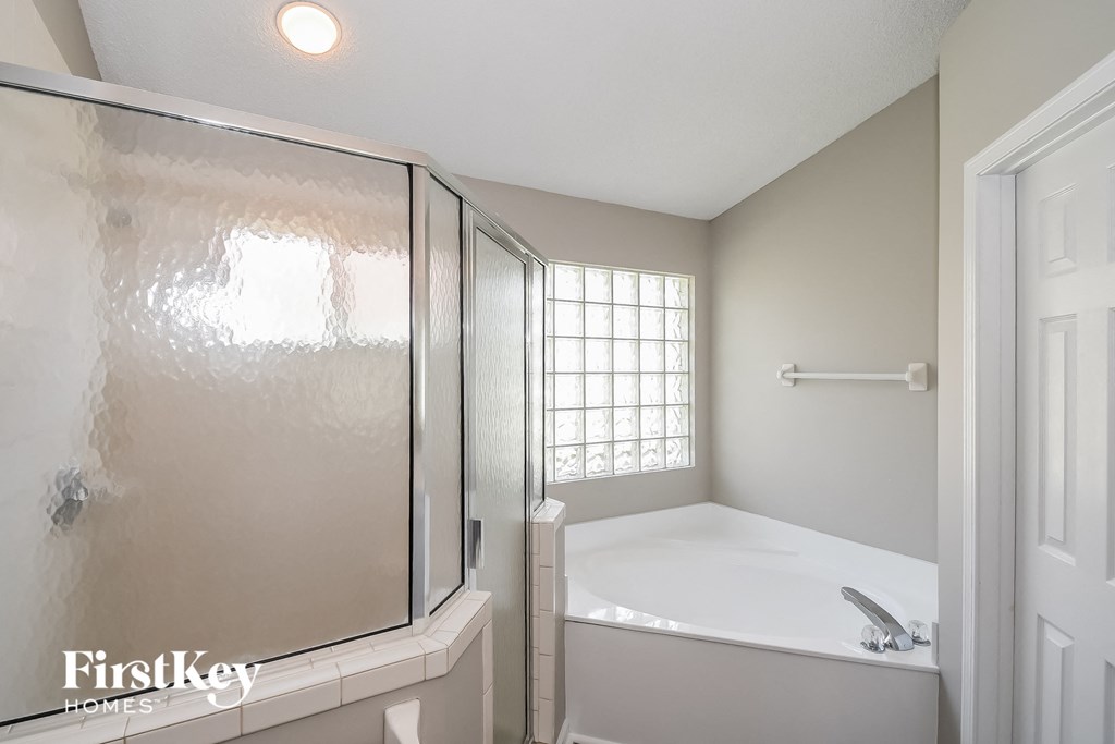a bathroom with a tub and a shower and a sink