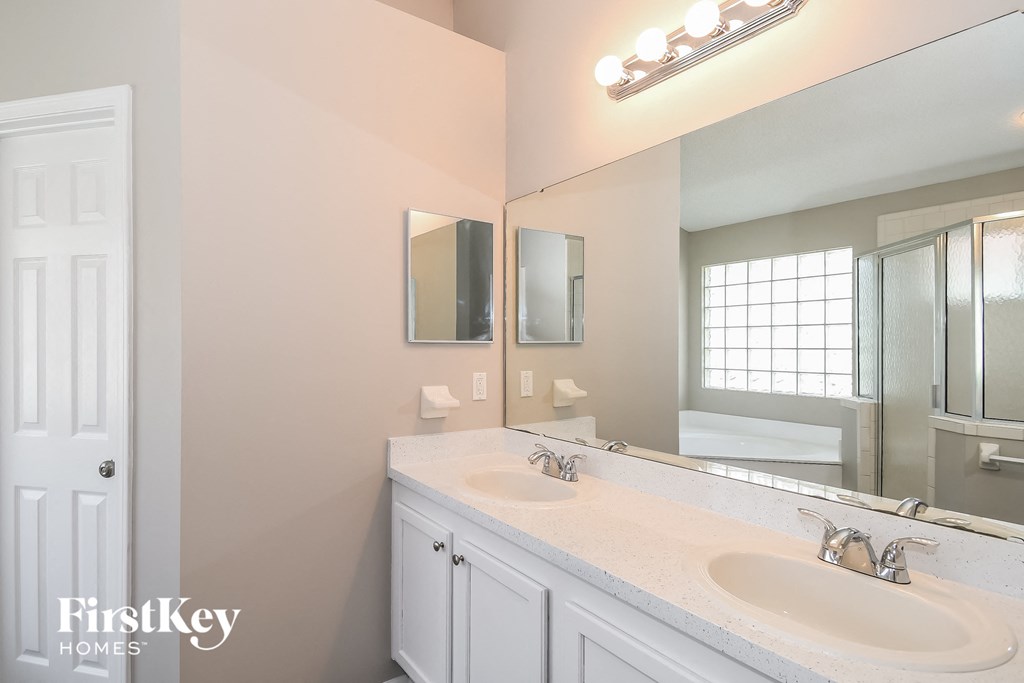 a bathroom with two sinks and a large mirror