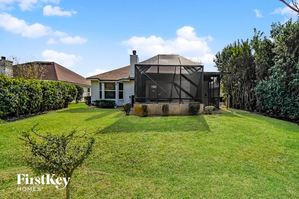 a backyard with a greenhouse in front of a house
