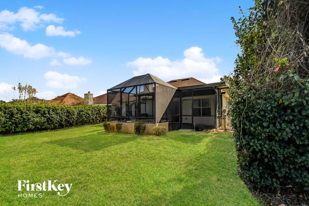 a house with glass windows and a grass yard