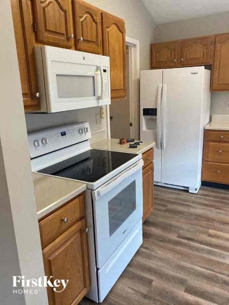 A kitchen with wooden cabinets and white appliances.