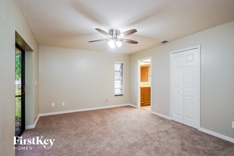 a living room with carpet and a ceiling fan