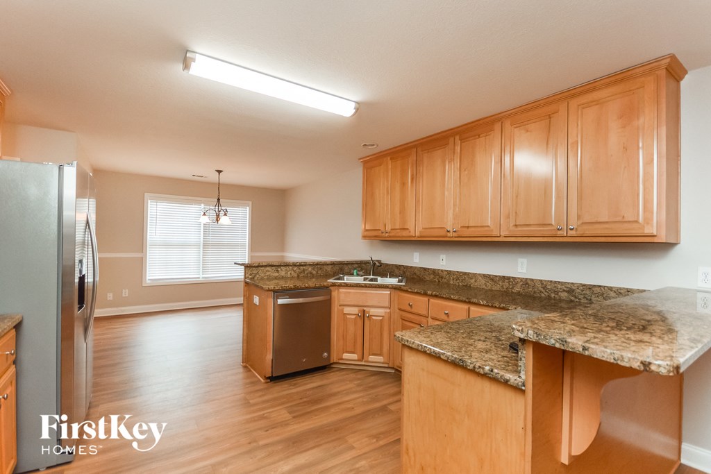 an empty kitchen with wooden cabinets and granite counter tops