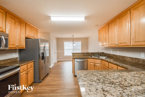 a kitchen with wooden cabinets and granite counter tops and stainless steel appliances