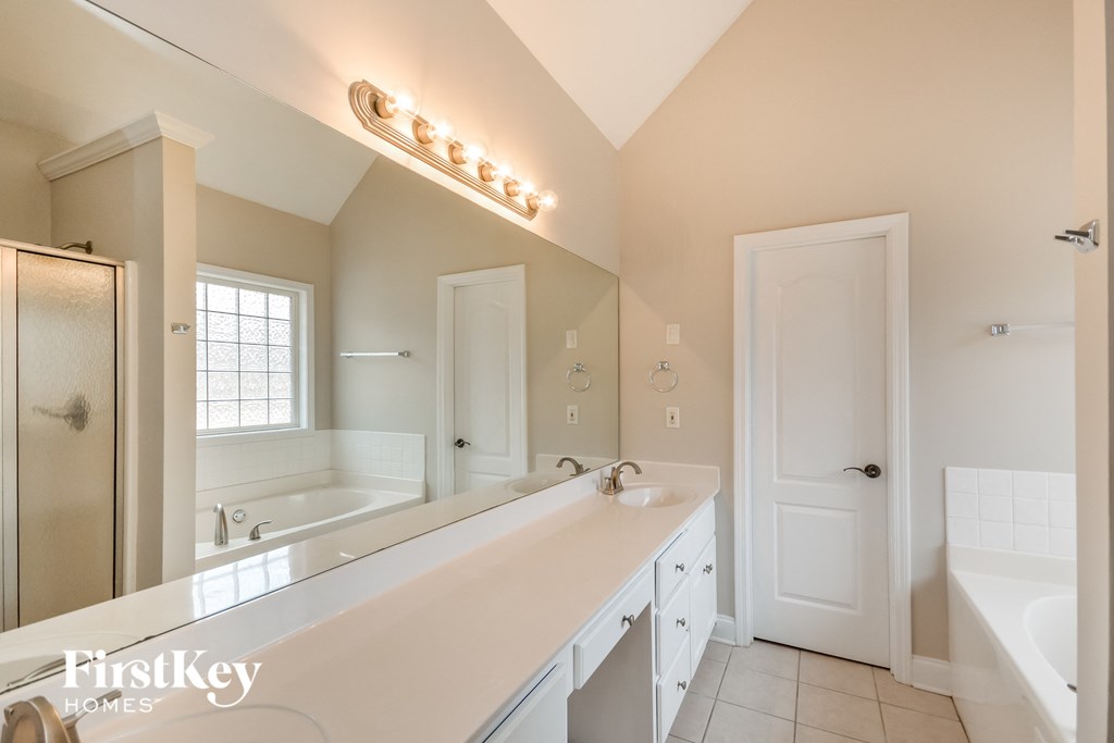 a bathroom with a large mirror and a sink and a tub