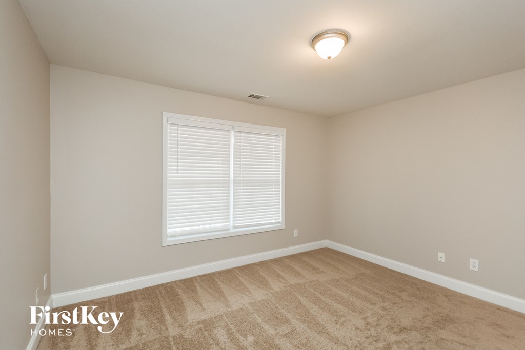 the second bedroom is spacious and light filled with carpet and a large window