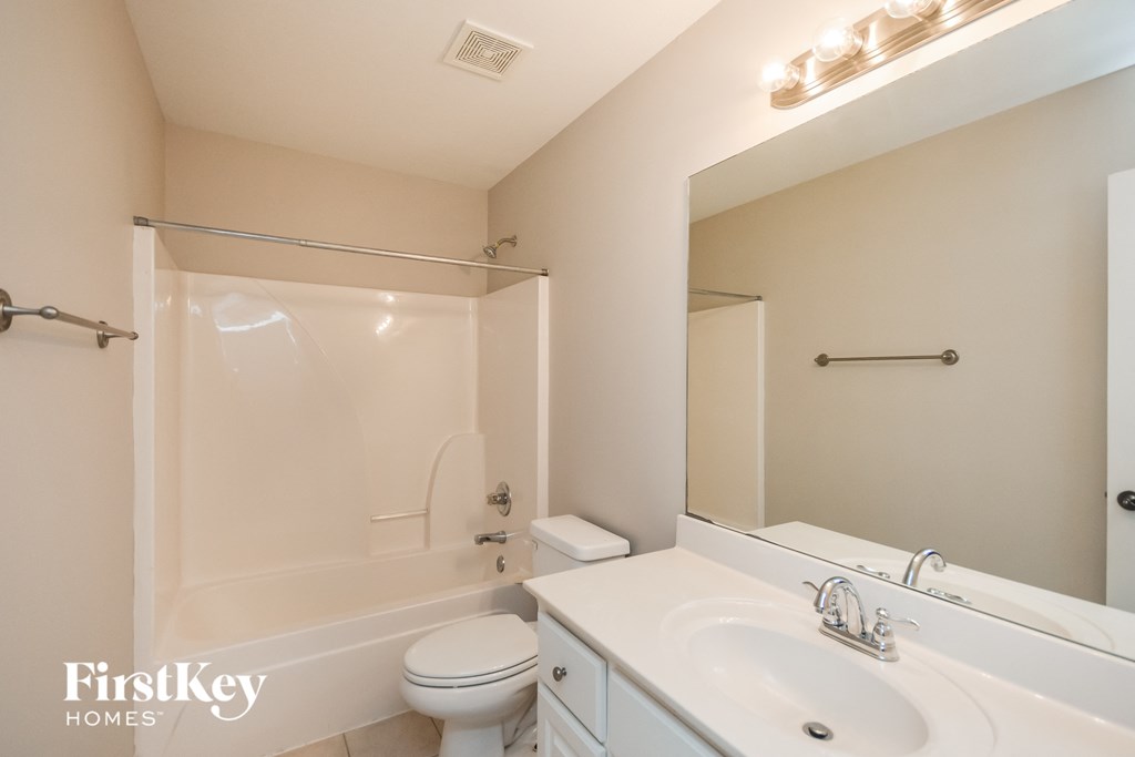 a bathroom with a sink toilet and shower and a mirror
