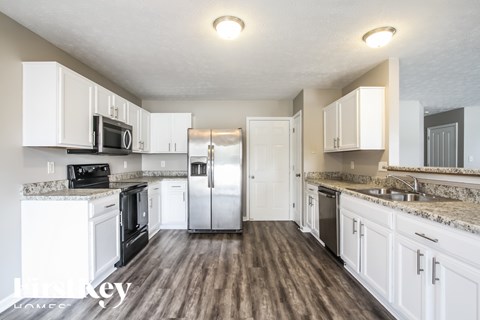 A kitchen with white cabinets and a granite counter top.