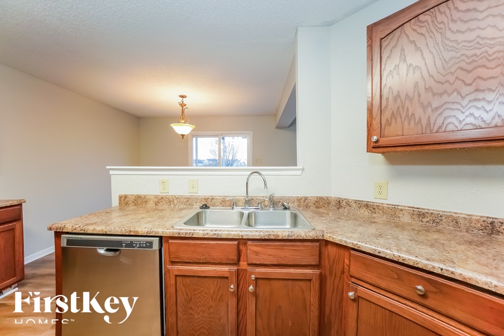 A kitchen with wooden cabinets and a granite countertop.