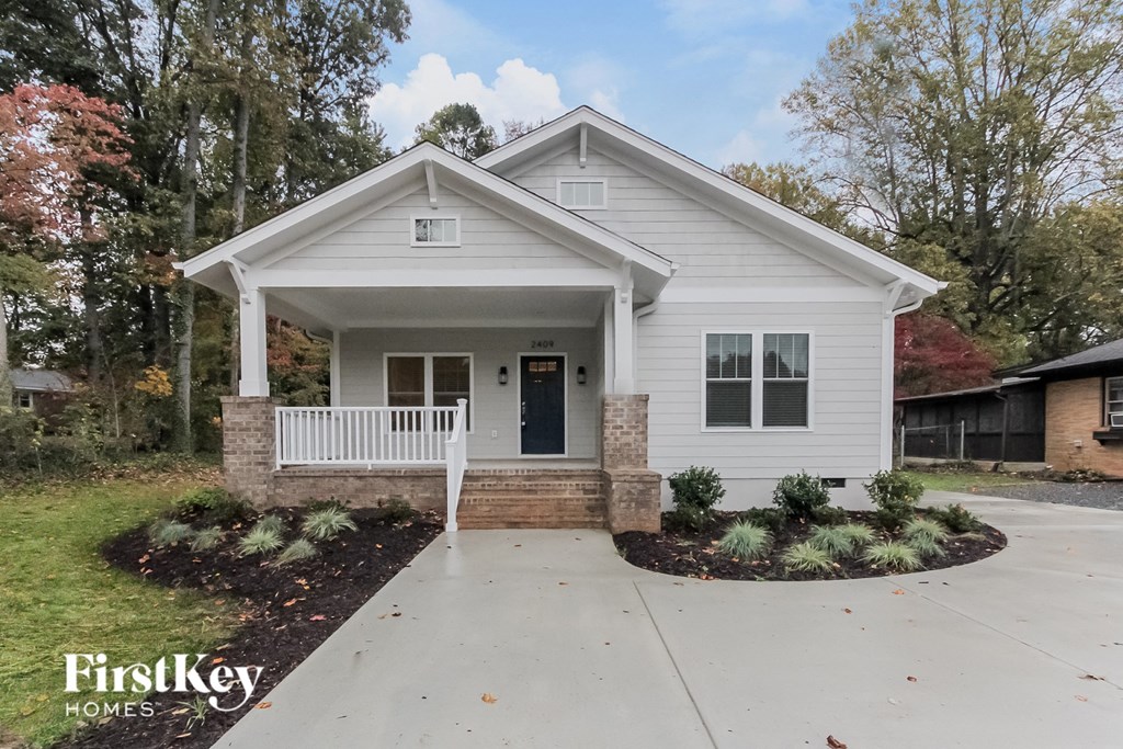 a white house with a front porch and a porch swing