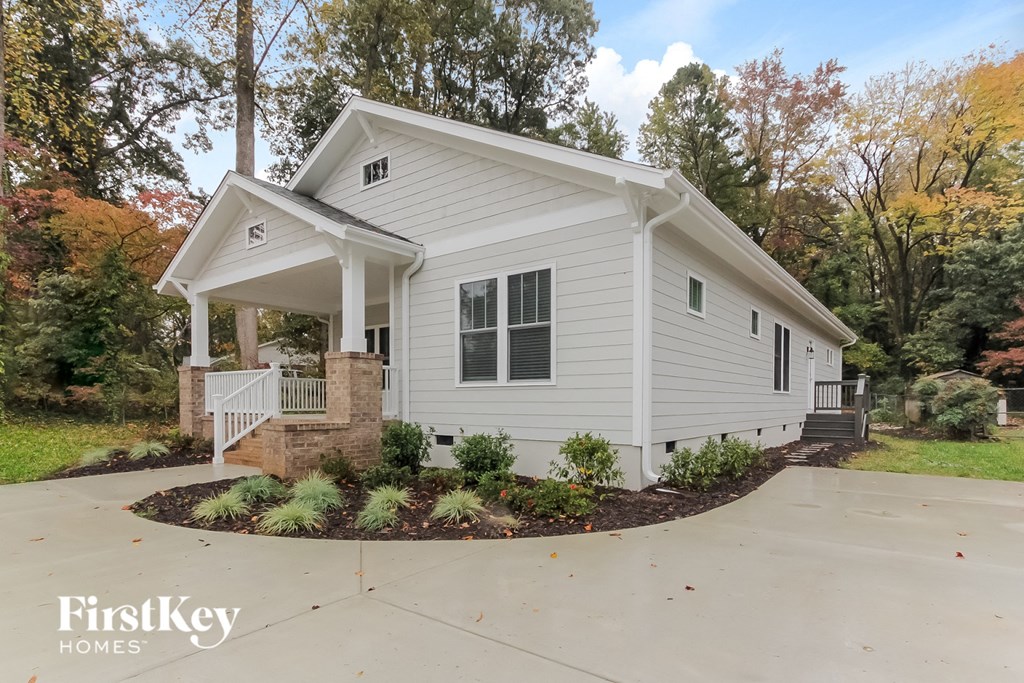 a white house with a porch and a driveway