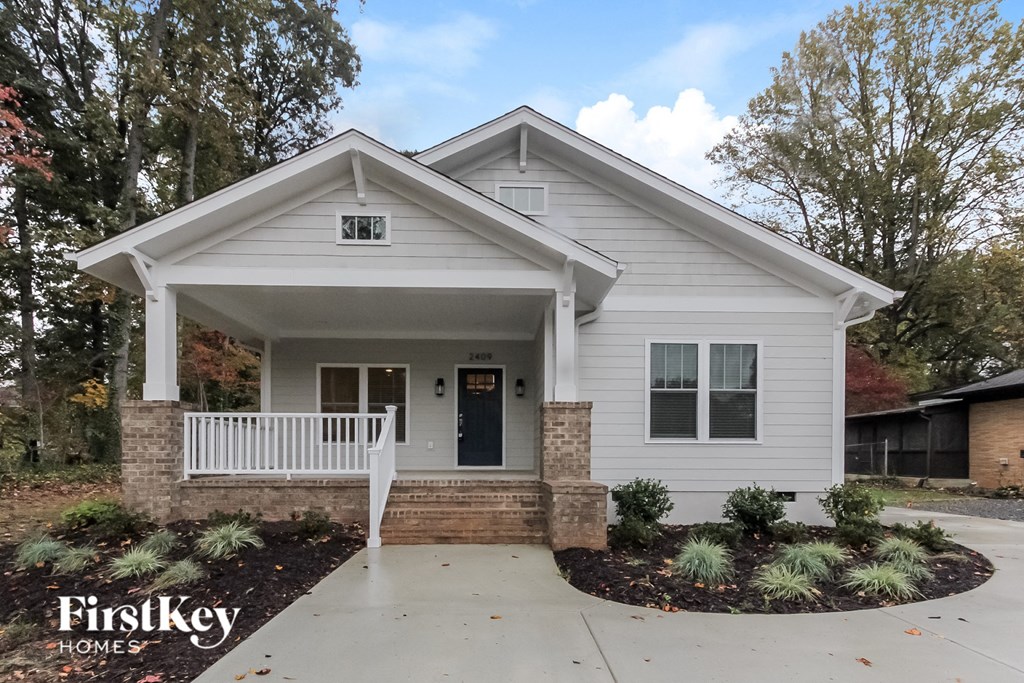 a white bungalow with a porch and a white front door