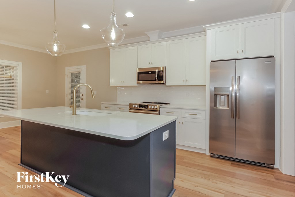 a white kitchen with stainless steel appliances and white cabinets