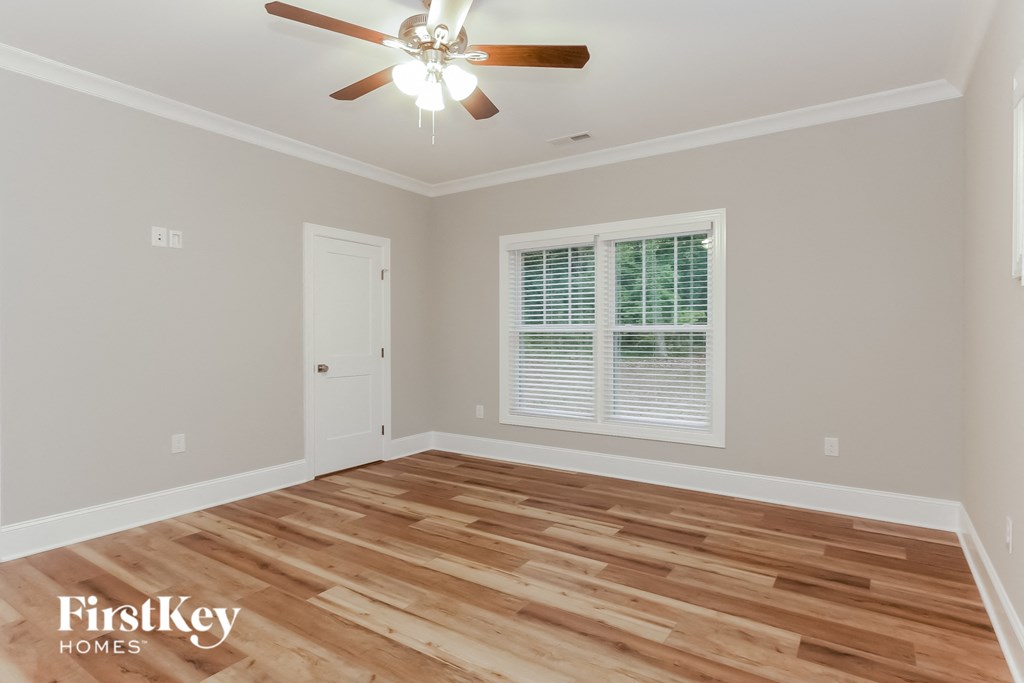 the living room after remodeling with wood flooring and a ceiling fan