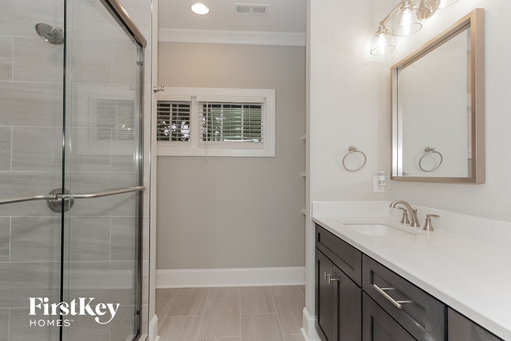 a bathroom with a shower and a sink and a mirror