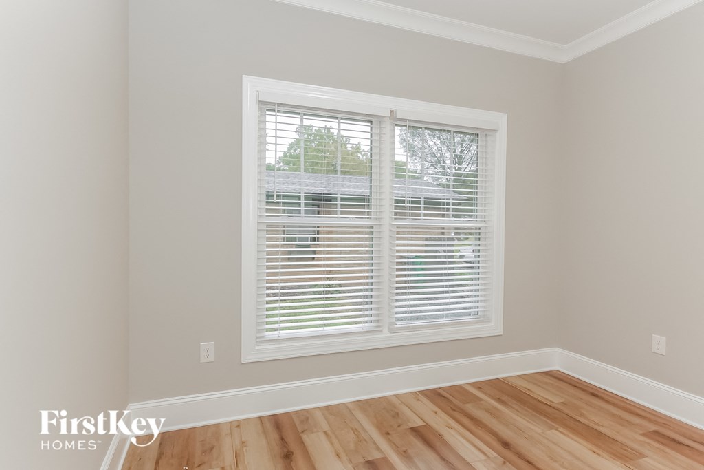 a living room with a large window and wooden floors