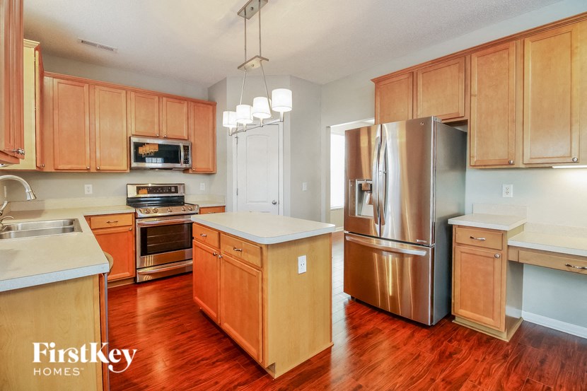 a kitchen with wooden cabinets and stainless steel appliances