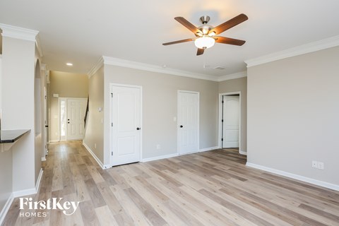 A spacious room with a ceiling fan and wooden flooring.